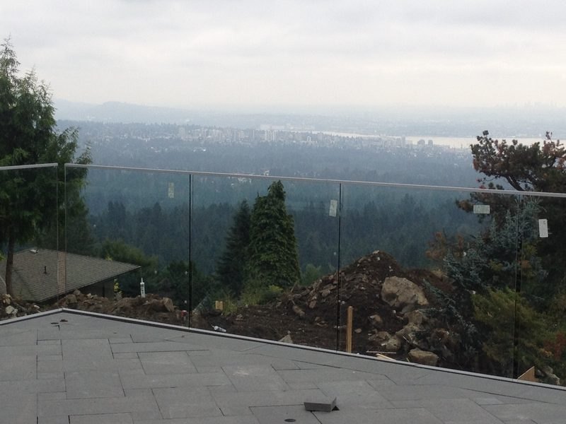 Glass deck railing on a hillside patio overlooking North Vancouver and the city